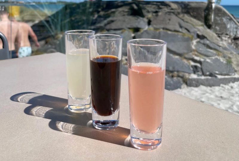 Palma Shotglas 6cl från Barcompagniet med 3 olika drycker i solen på uteserveringen på Strandtugg i Höllviken.